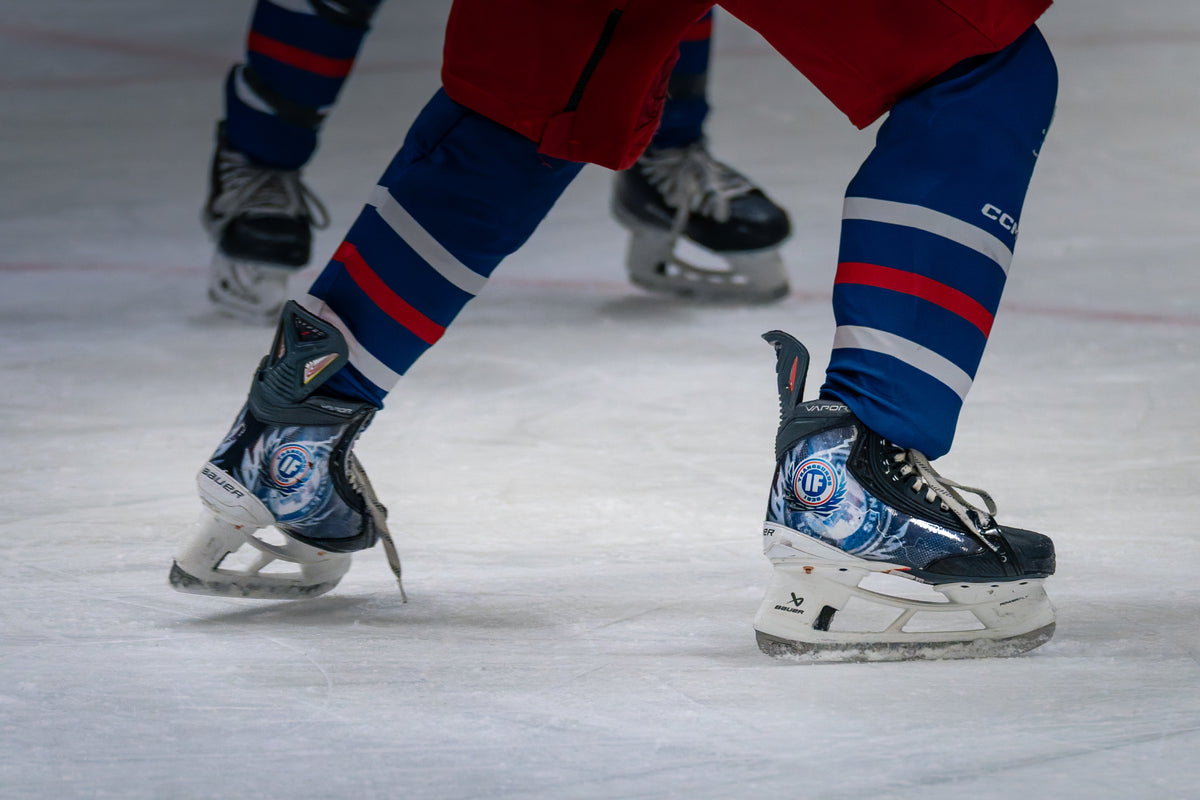Two players on the ice with matching club skins on their skates