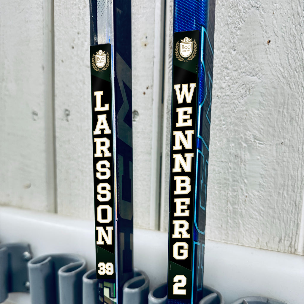 Boo Hockey stick stickers applied to two hockey sticks in a rack