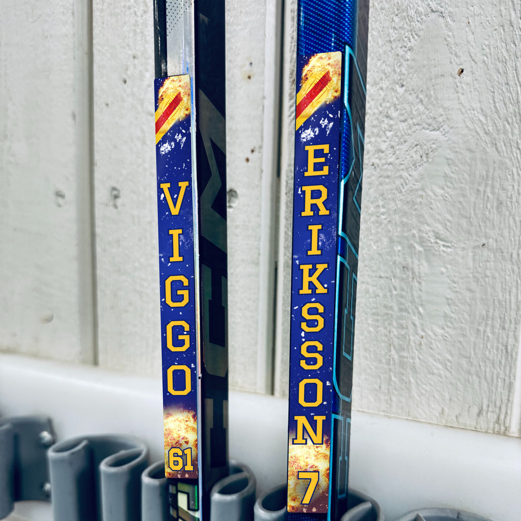 Djurgården stick stickers applied to two hockey sticks in a rack