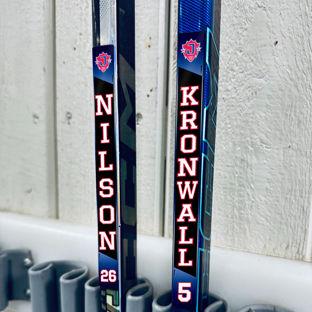 Järfälla HC stick stickers applied to two hockey sticks in a rack