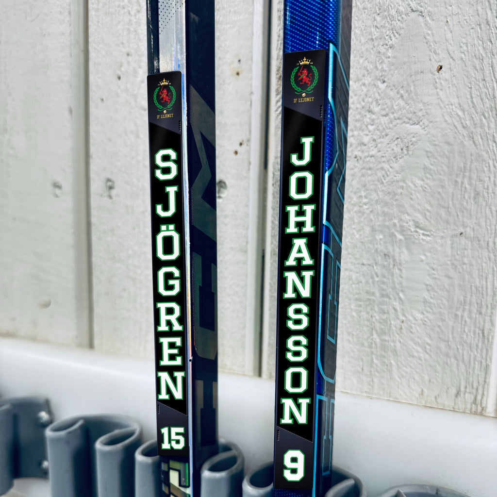 IF Lejonet stick stickers applied to two hockey sticks in a rack